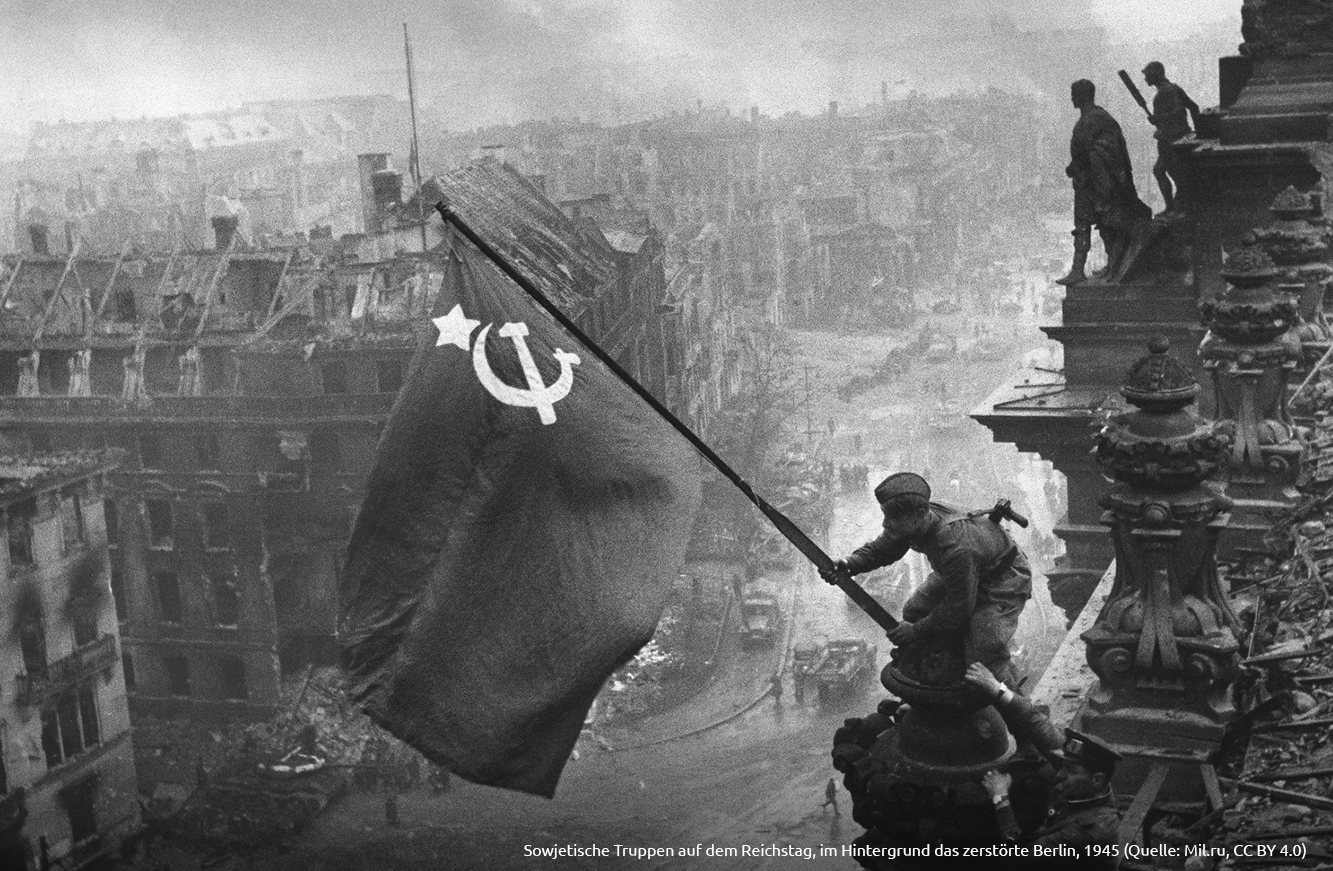 Sowjetische Truppen auf dem Reichstag im Hintergrund das zerstörte Berlin 1945 Quelle Mil.ru CC-BY-4.0